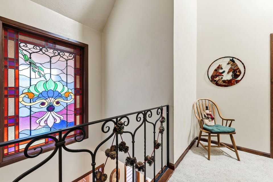 Discover stunning stained glass artistry and charming decorative touches in this bright, welcoming stairway landing.