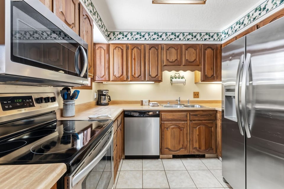 Your fully equipped kitchen features stainless steel appliances and warm wood cabinets, perfect for preparing memorable meals during your stay.