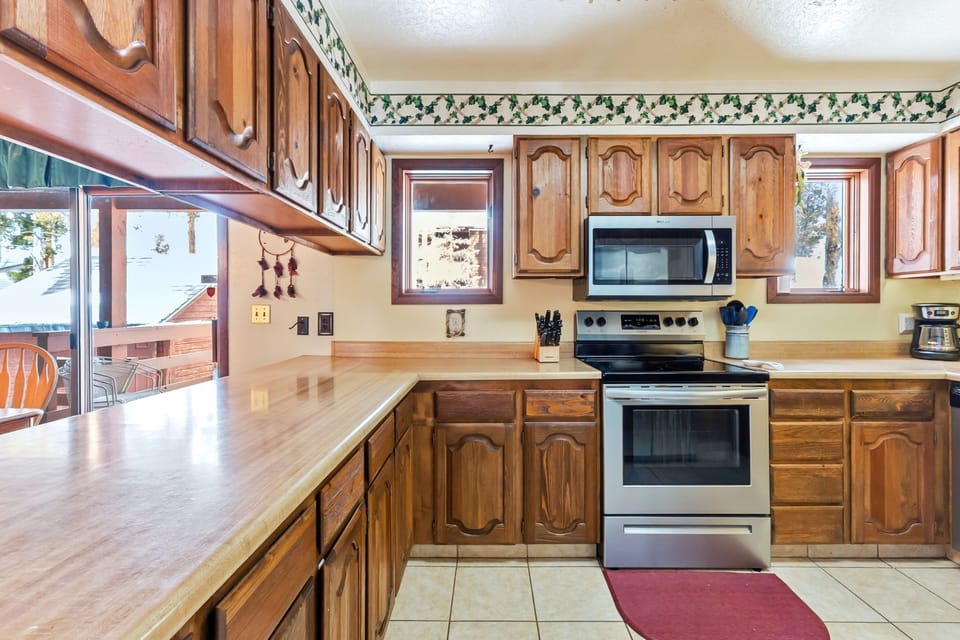 Your fully equipped kitchen features warm wood cabinets, modern appliances, and stunning mountain views while you cook your favorite meals.