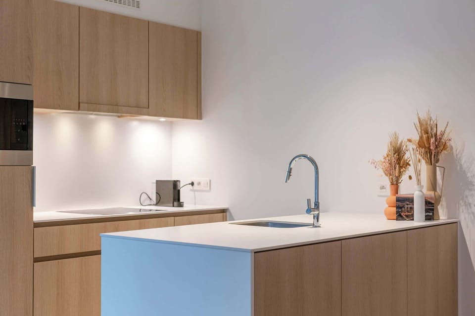 A warm, open-plan living space with a fully equipped kitchen and a dining table for four