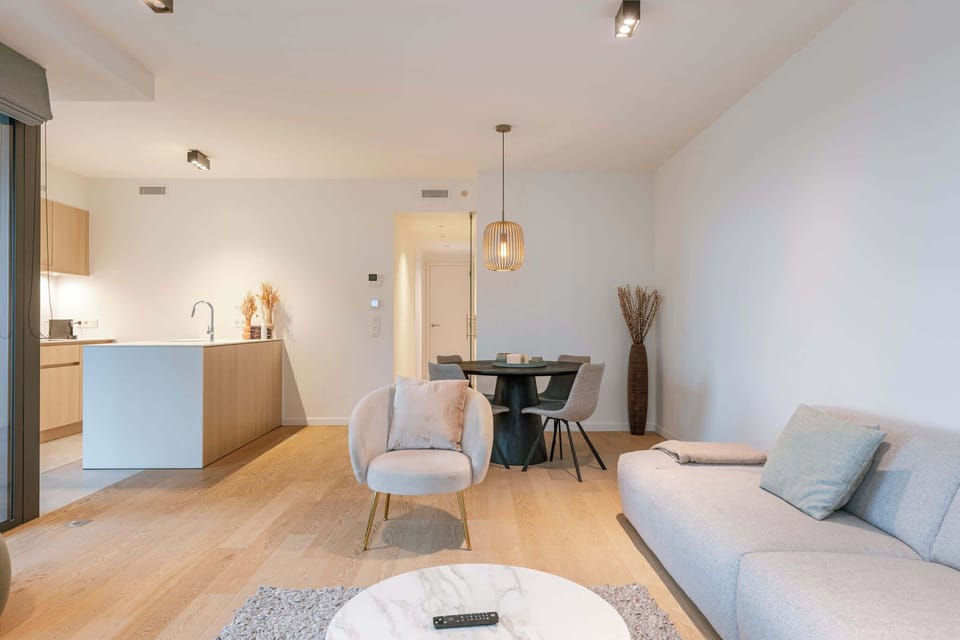 A warm, open-plan living space with a fully equipped kitchen and a dining table for four