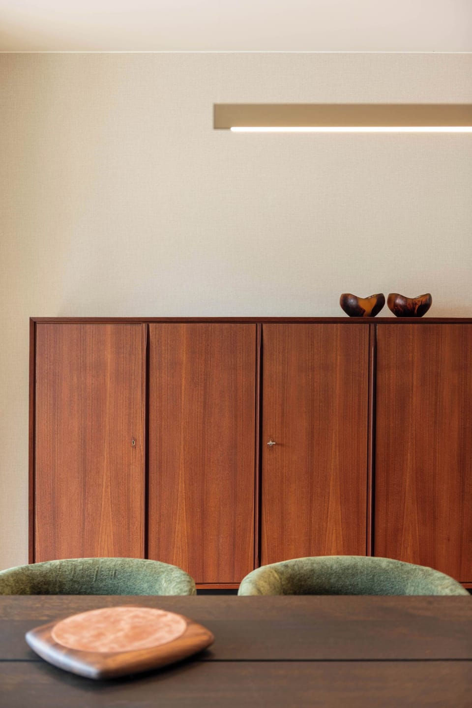 Warm and elegant dining area with rich wood tones and soft, inviting seating.