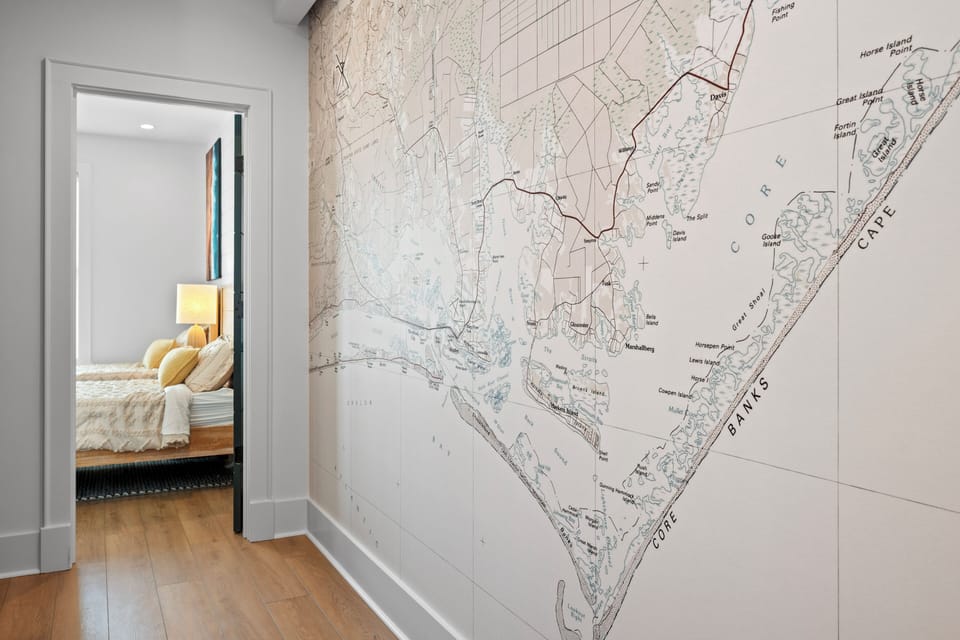 Your hallway features a stunning nautical chart wall mural connecting to the cozy bedroom, creating an inspired coastal atmosphere.