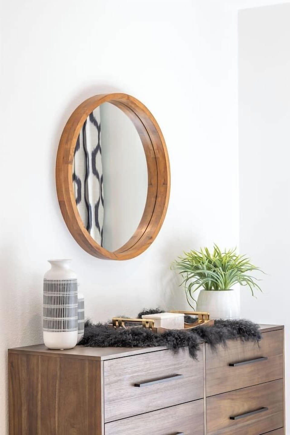 Bedroom 2 features a spacious dresser with ample storage, styled with warm wood tones and thoughtful décor. Ideal for unpacking and settling in, this piece adds both function and a polished, hotel-inspired feel to the room.