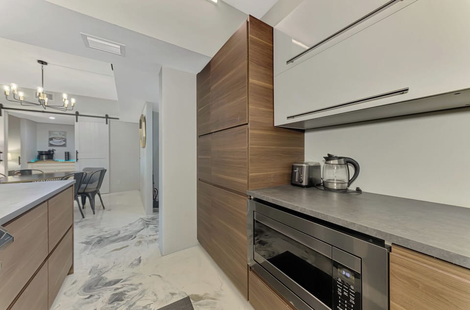 You'll love preparing meals in this sleek modern kitchen with stunning wood cabinets, granite counters, and premium appliances for your perfect getaway.