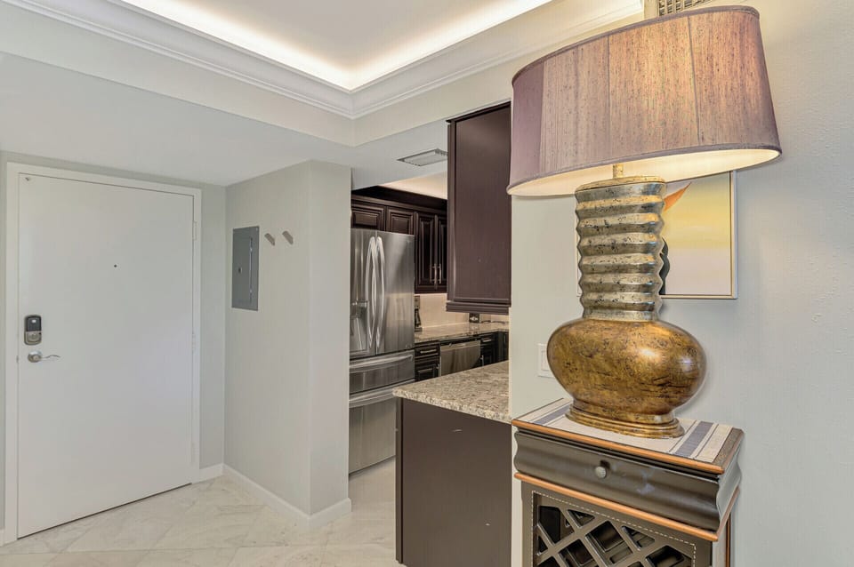 Step into your sophisticated suite where warm lighting and elegant furnishings create the perfect atmosphere for relaxation.