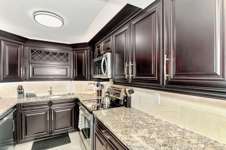 Your gourmet kitchen features rich mahogany cabinets, granite countertops, and premium stainless steel appliances for memorable cooking experiences.