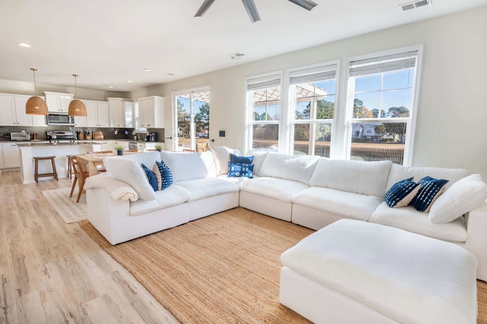 Spacious living room filled with natural light and seamless flow into the kitchen and dining area.