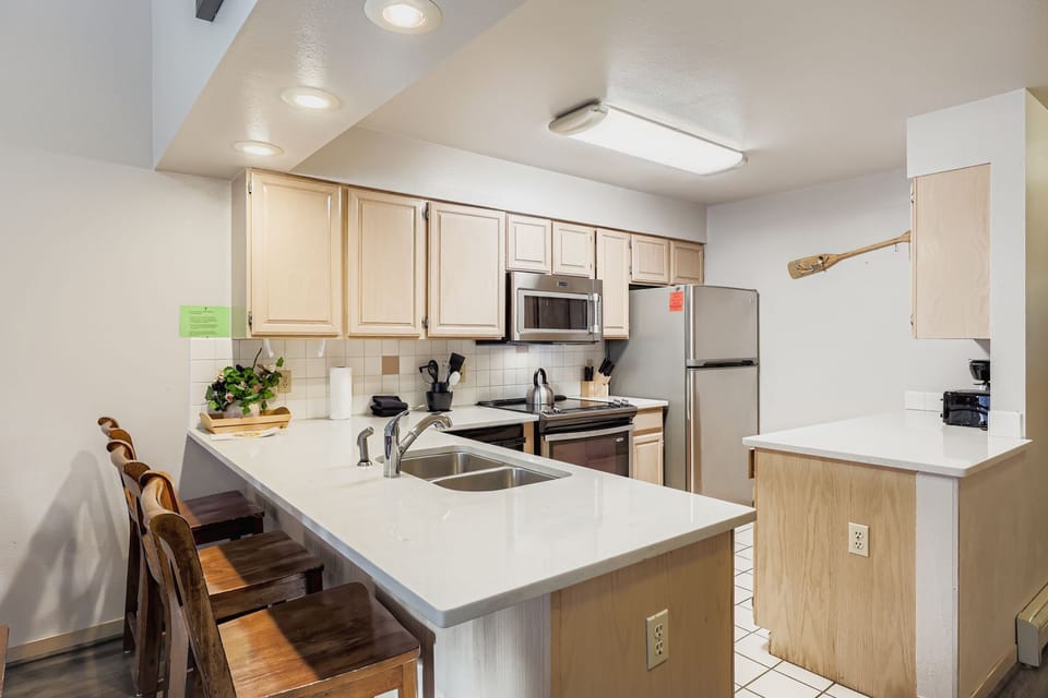Your fully-equipped kitchen awaits with stainless steel appliances, spacious countertops, and a breakfast bar for casual meals.