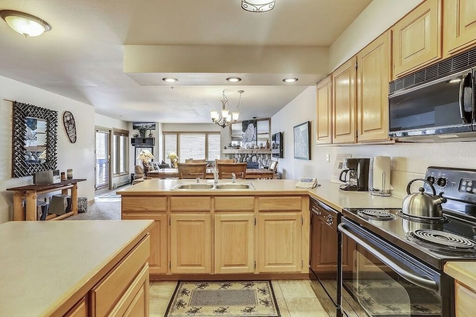 Your spacious kitchen features warm wood cabinets, ample counter space, and all modern appliances for preparing memorable meals together.