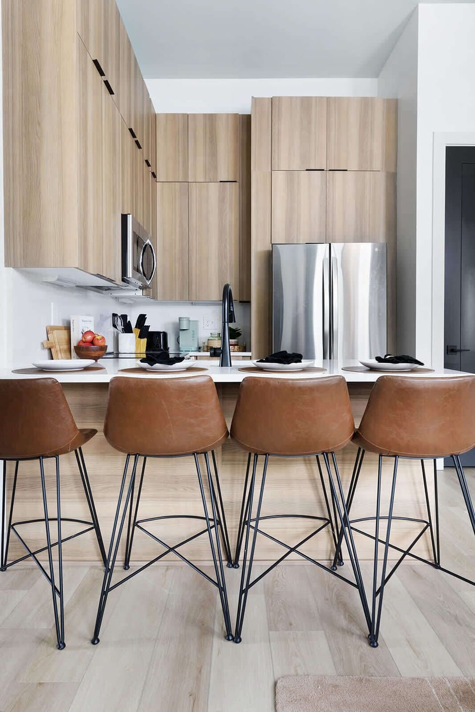 The breakfast bar is equipped with four comfortable, back-supported barstools.