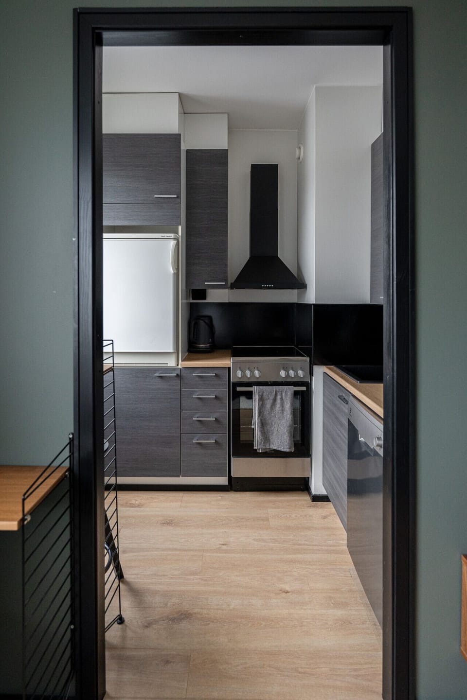 The modern kitchenette is fully equipped with integrated appliances, including a full-sized stove and oven for your cooking needs.