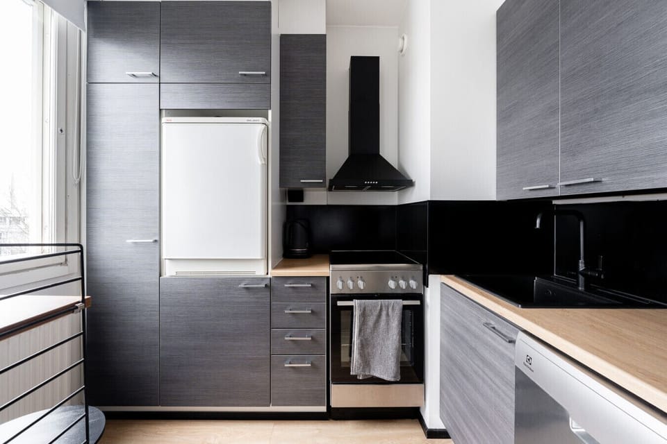 The modern kitchenette is fully equipped with integrated appliances, including a full-sized stove and oven for your cooking needs.