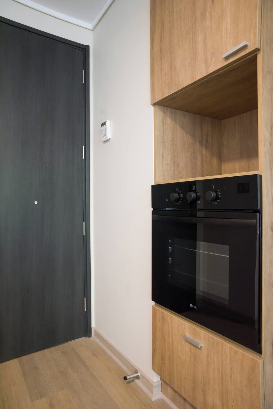 Modern kitchen with built-in oven and secure entry, perfect for cooking enthusiasts.
