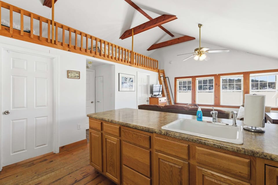 The breakfast bar fits 2–3 and sits at the heart of the open-concept space, with the loft ladder visible above.