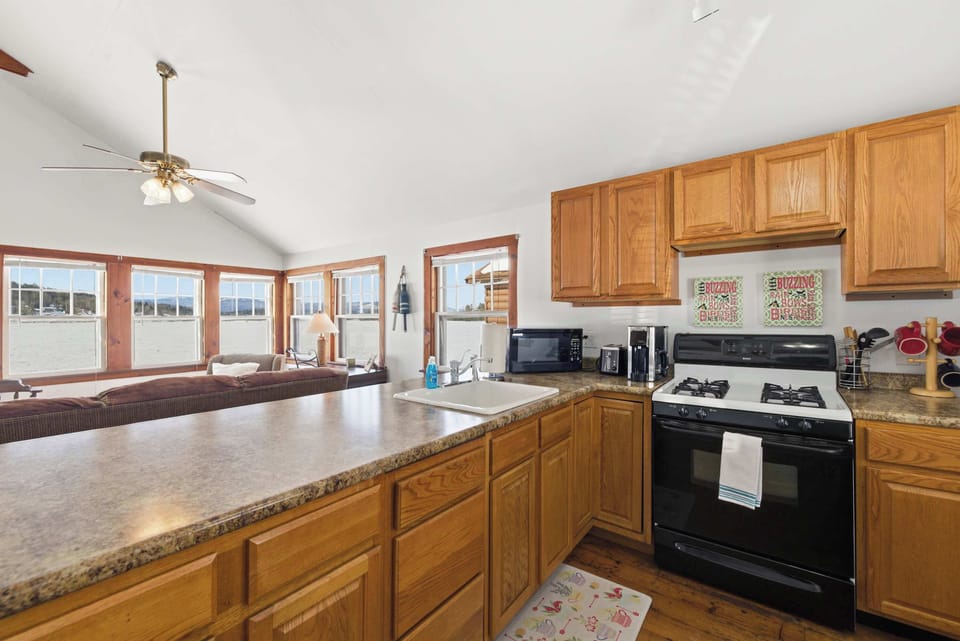 The open-concept kitchen looks out over the living space, with a gas range, full-size fridge, and a breakfast bar that makes casual mornings feel easy.
