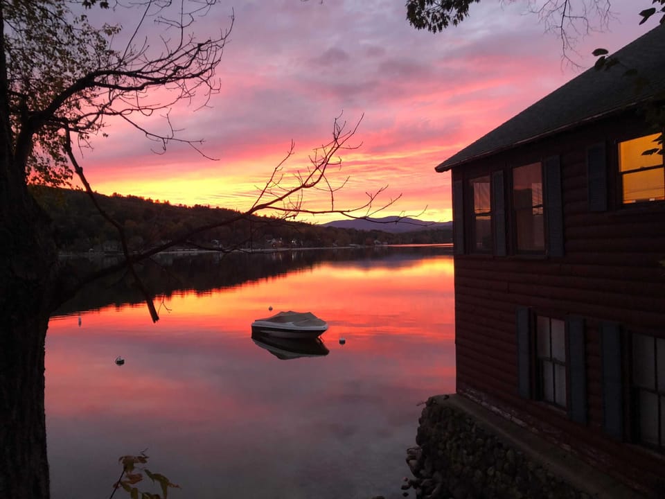 The lake holds every color of the sunset like a mirror — this is the view from the waterfront on a clear evening.