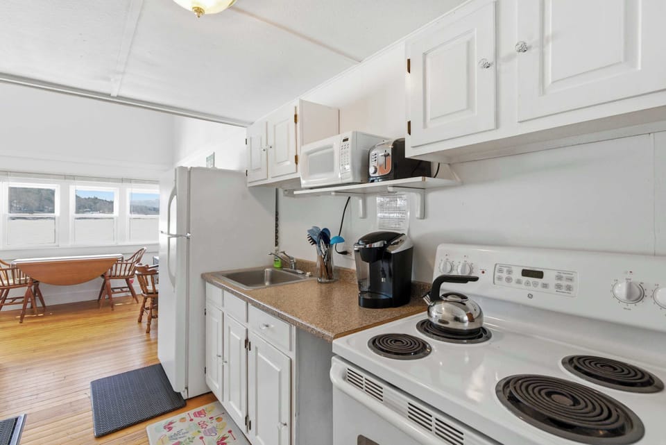 The kitchen sits just off the living area with an electric range, full-size refrigerator, and everything you need to cook a full meal without hunting for equipment.