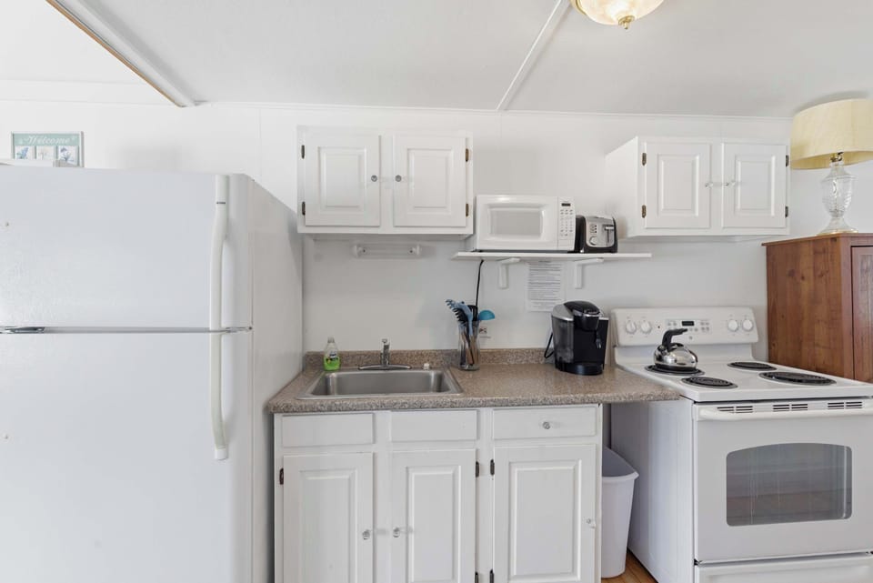 A closer look at the kitchen — the electric range, microwave, and Keurig are all within easy reach for morning coffee or a home-cooked dinner.