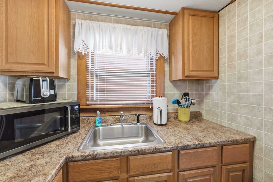 The sink and counter corner show a fully set-up kitchen — microwave, toaster, and all the basics within reach.
