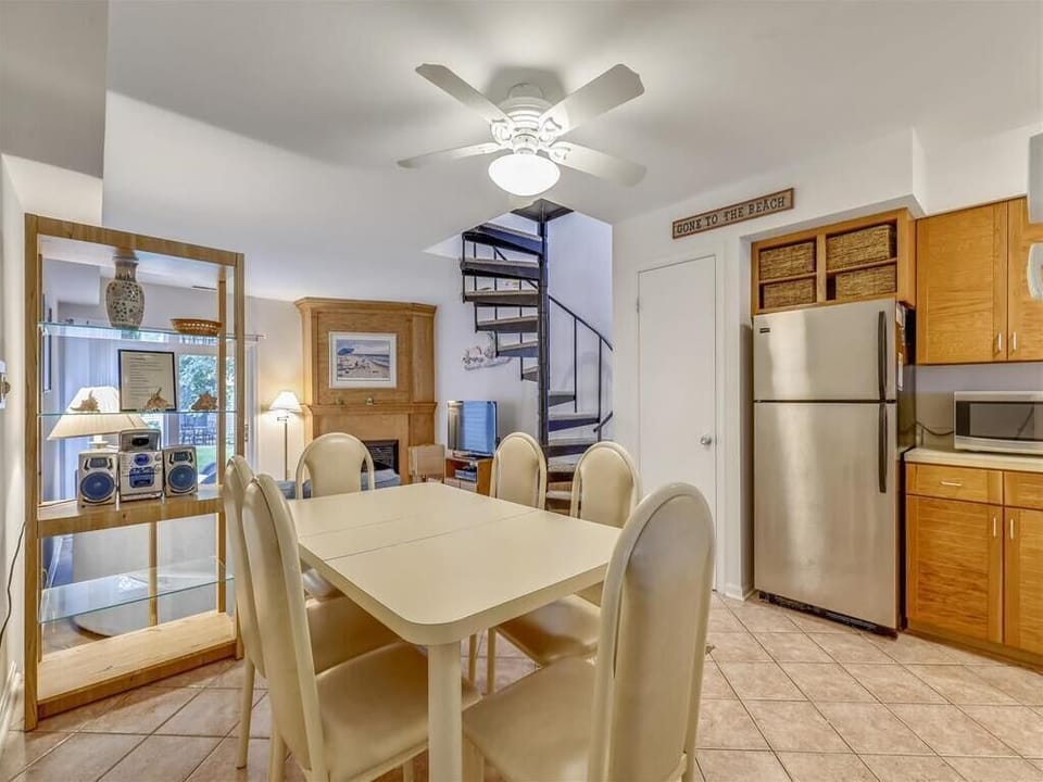 Gather around the dining table, perfect for sharing meals and laughs after a day at the beach.