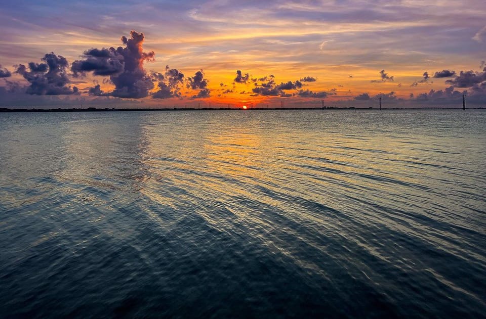 Experience the serenity of sunset casting golden hues over the calm water, a perfect moment to unwind.