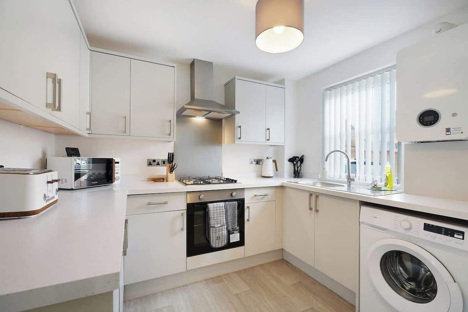 Kitchen equipped with all essentials, including a washer, gas hob, oven, fridge, microwave, kettle, toaster, and full cookware set.