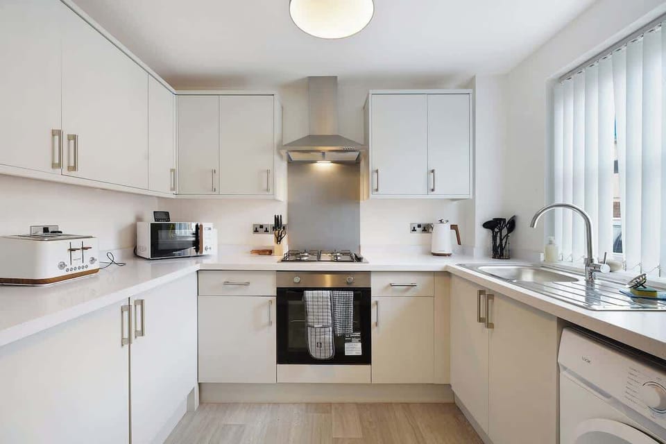 Kitchen equipped with all essentials, including a washer, gas hob, oven, fridge, microwave, kettle, toaster, and full cookware set.