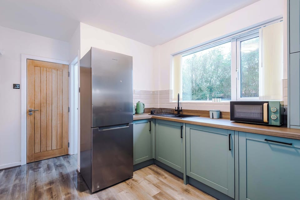 Kitchen: Bright and modern space with stylish appliances and a view of lush greenery!