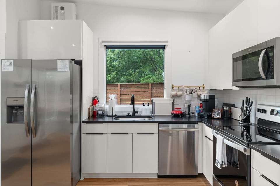 Bright modern kitchen with stainless steel appliances and garden-view window