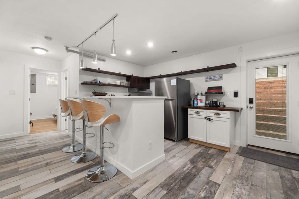 Bright modern kitchen with breakfast bar, stainless appliances, and outdoor access