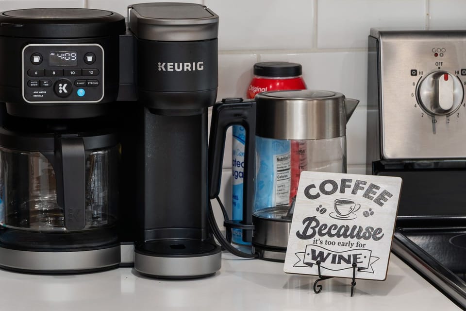 Well-stocked coffee station with drip maker, Keurig, and kettle