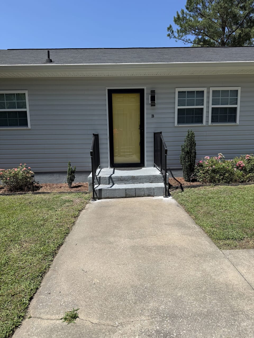Welcoming front entry with tidy landscaping and easy walkway access