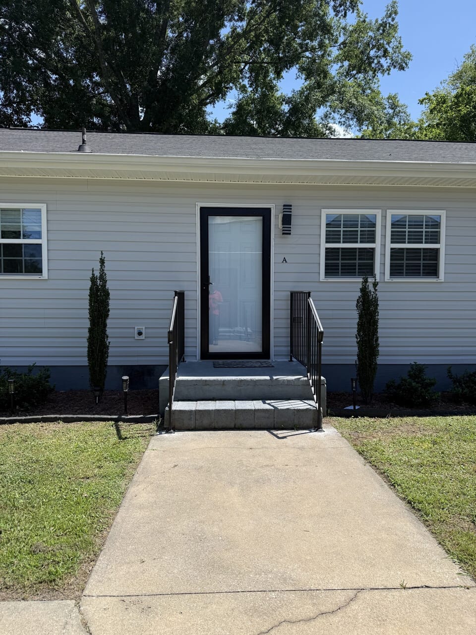 Welcoming private entrance with clean walkway and tidy landscaping