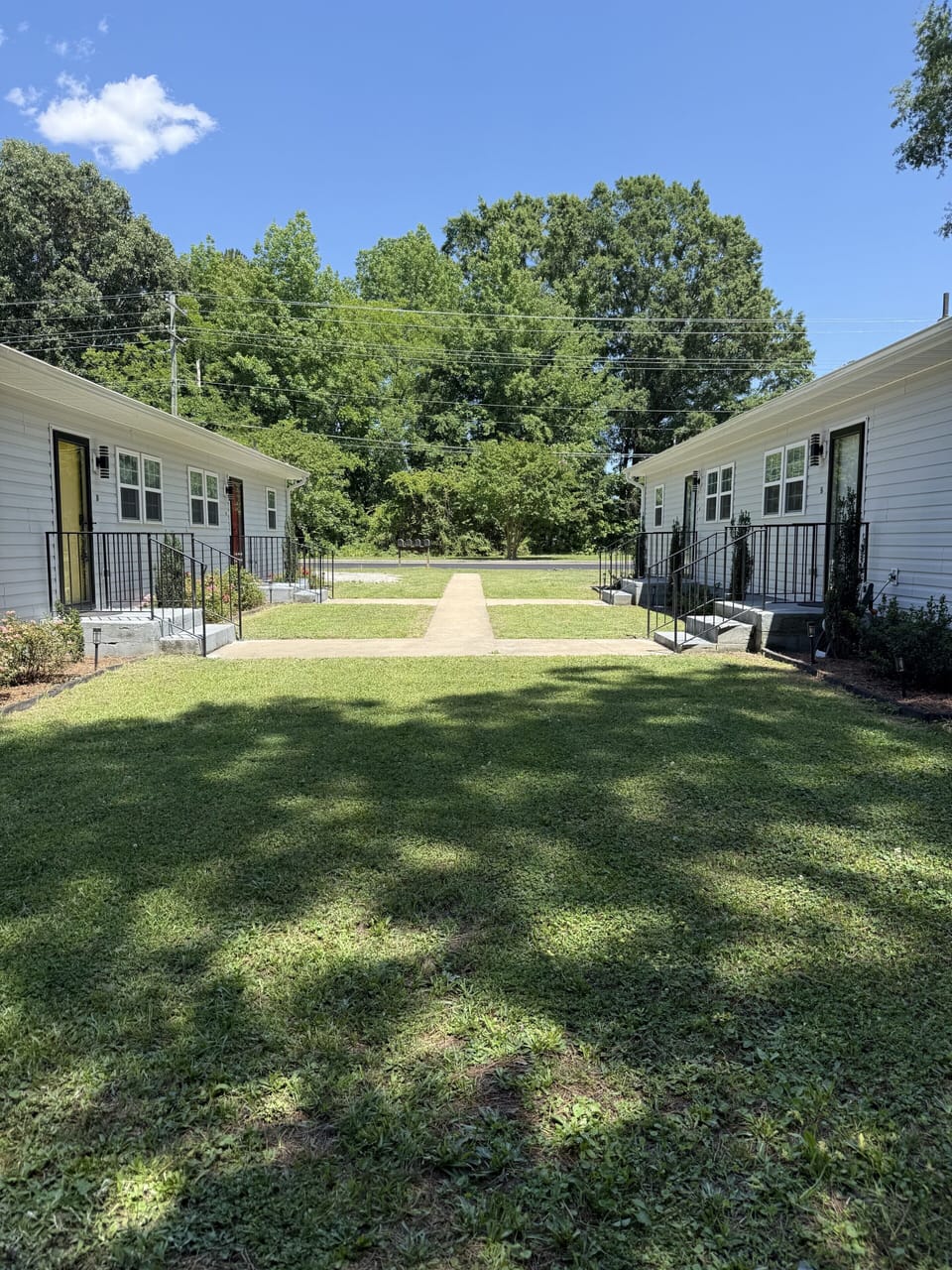 Spacious green courtyard between charming cottages under mature trees