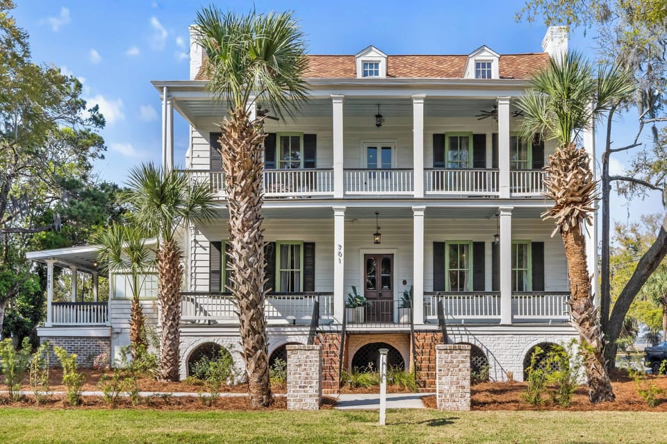 Classic Southern charm welcomes you home with towering columns, wraparound porches, and lush coastal landscaping!