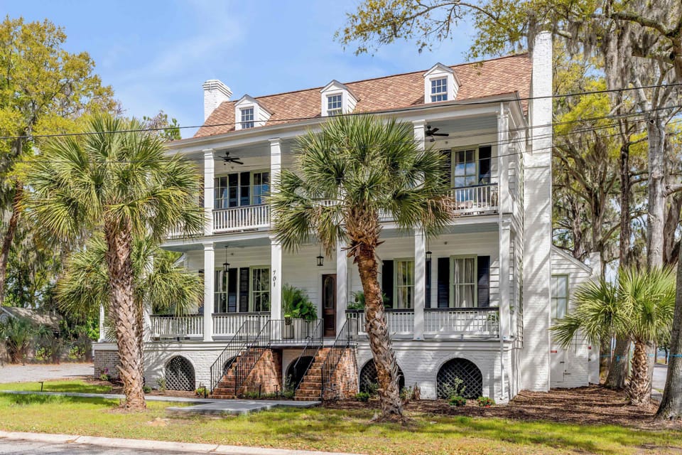 Classic Southern charm welcomes you home with towering columns, wraparound porches, and lush coastal landscaping!