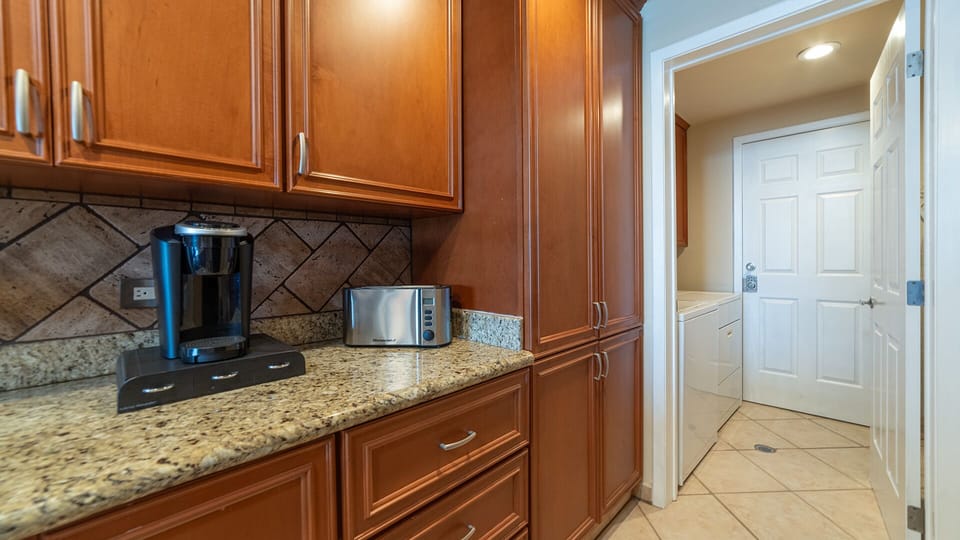 The kitchen leads to the washer and dryer.
