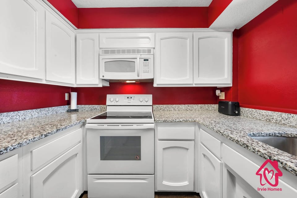 Modern kitchen with sleek white cabinetry and granite countertop.
