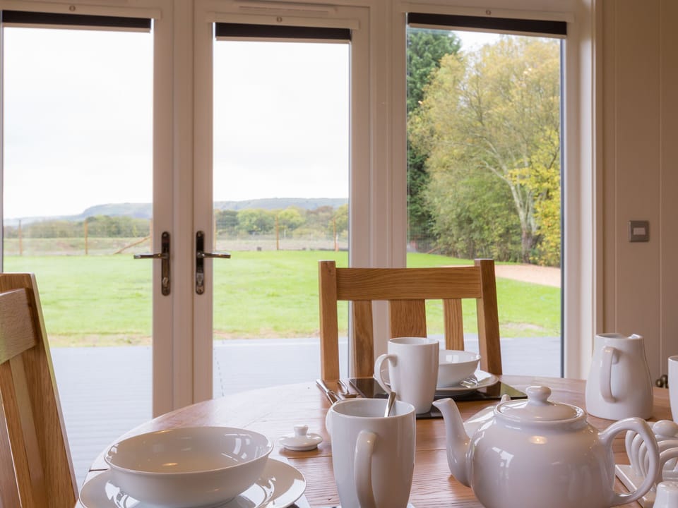 Dining area overlooking the decked area | Maple Lodge - South Downs Lodges, Hassocks
