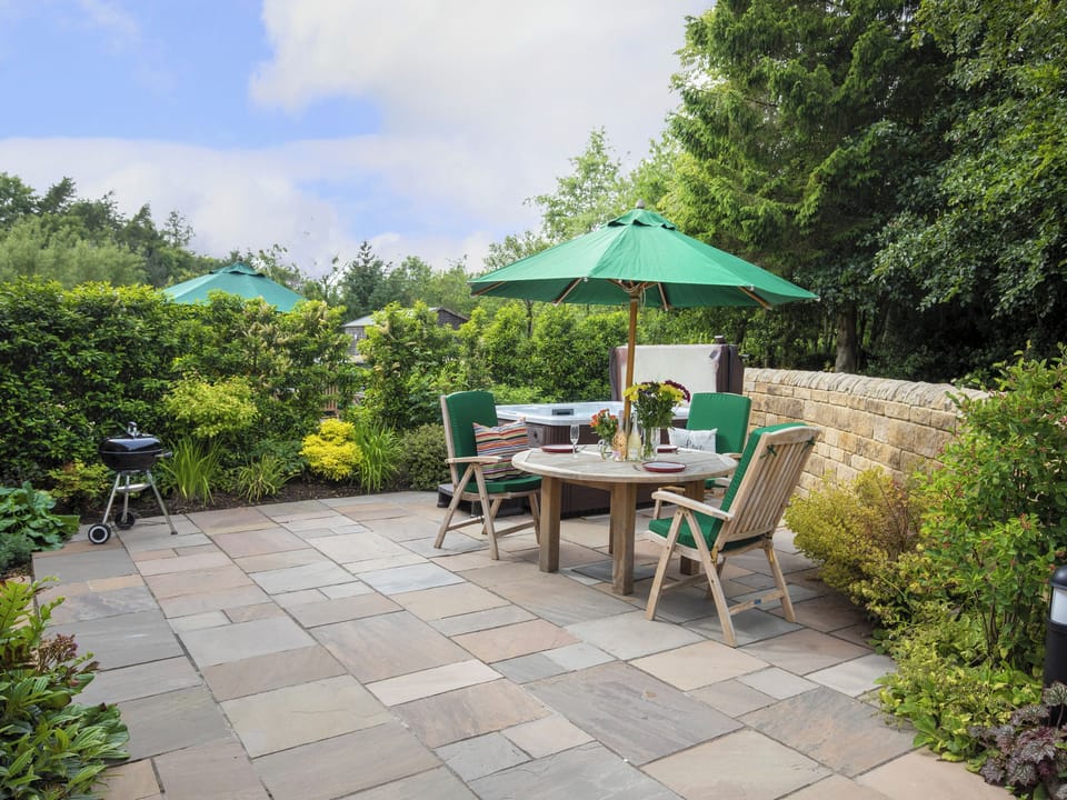 Paved patio with outdoor furniture and hot tub | Holly Cottage, Harwood Dale, near Scarborough