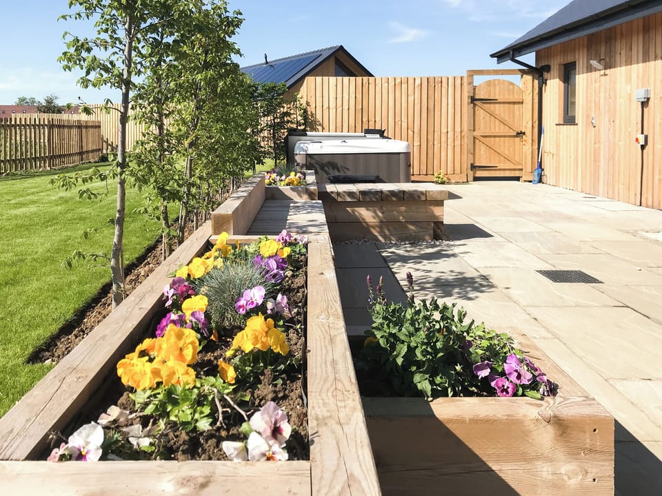 Delightful planted raised beds and a lovely welcoming hot tub | Water Lily Cottage - Ashlin Farm Barns, Dunholme, near Lincoln
