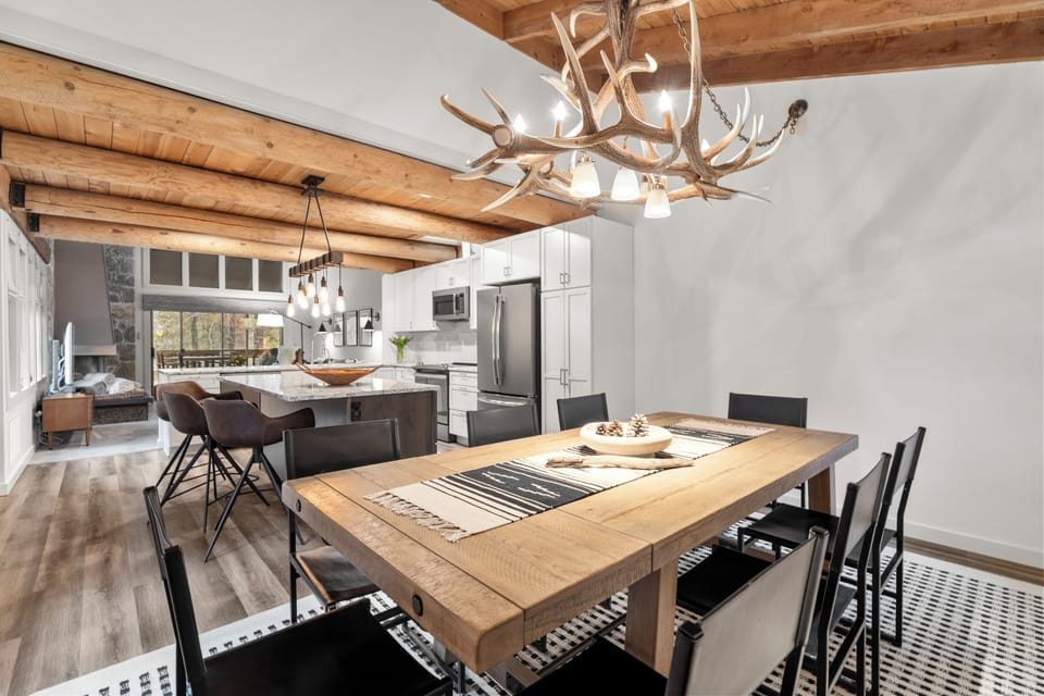 Gather around your rustic dining table beneath the stunning antler chandelier, while the open kitchen invites culinary adventures.