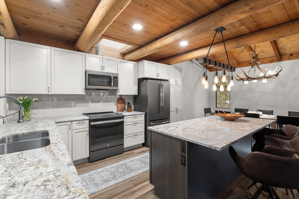 Your modern kitchen blends rustic charm with luxury—gleaming granite counters beneath exposed wood beams invite you to create memorable meals together.
