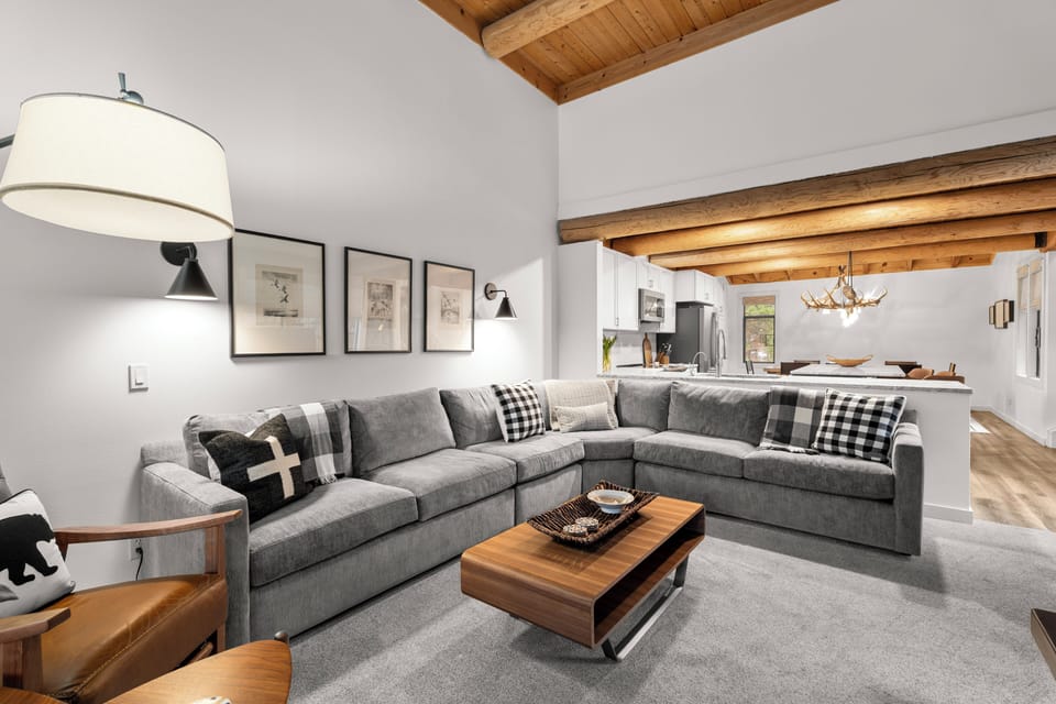 Sink into this cozy gray sectional where exposed beams create rustic charm above your head and modern comfort surrounds you.