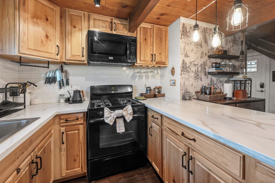 Full Kitchen - The upscale galley kitchen features quartz countertops, a gas range, and modern appliances, making meal prep simple and enjoyable.