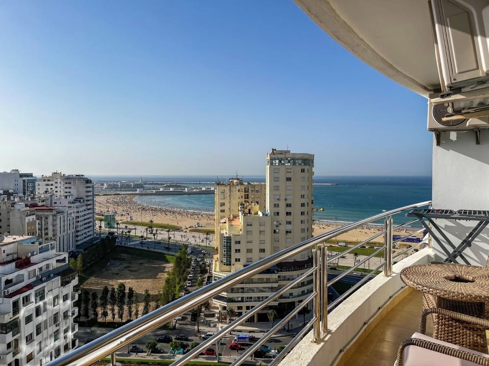 Balcony with sea view, clothes drying rack, table, and chairs