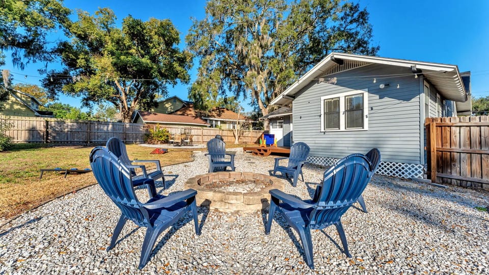 Spacious city backyard with outdoor games, fire pit, grill, and plenty of seating to relax and enjoy the Florida weather.