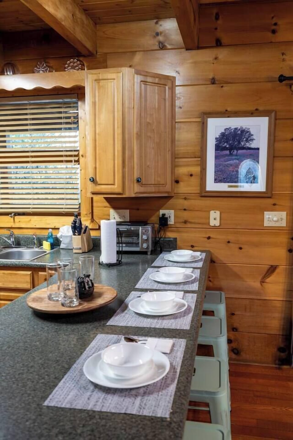 Your rustic log cabin kitchen awaits with warm wood charm, granite counters, and everything ready for memorable meals together.