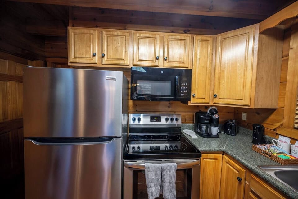 Your fully equipped kitchen features stainless steel appliances and rich wood cabinetry, perfect for preparing meals during your mountain getaway.